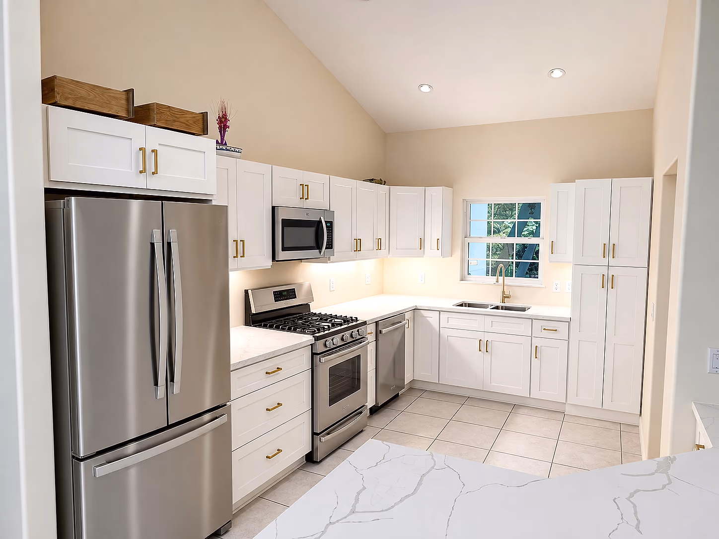 Completed Bradenton kitchen restoration with white shaker cabinets, brass hardware, and quartz countertops